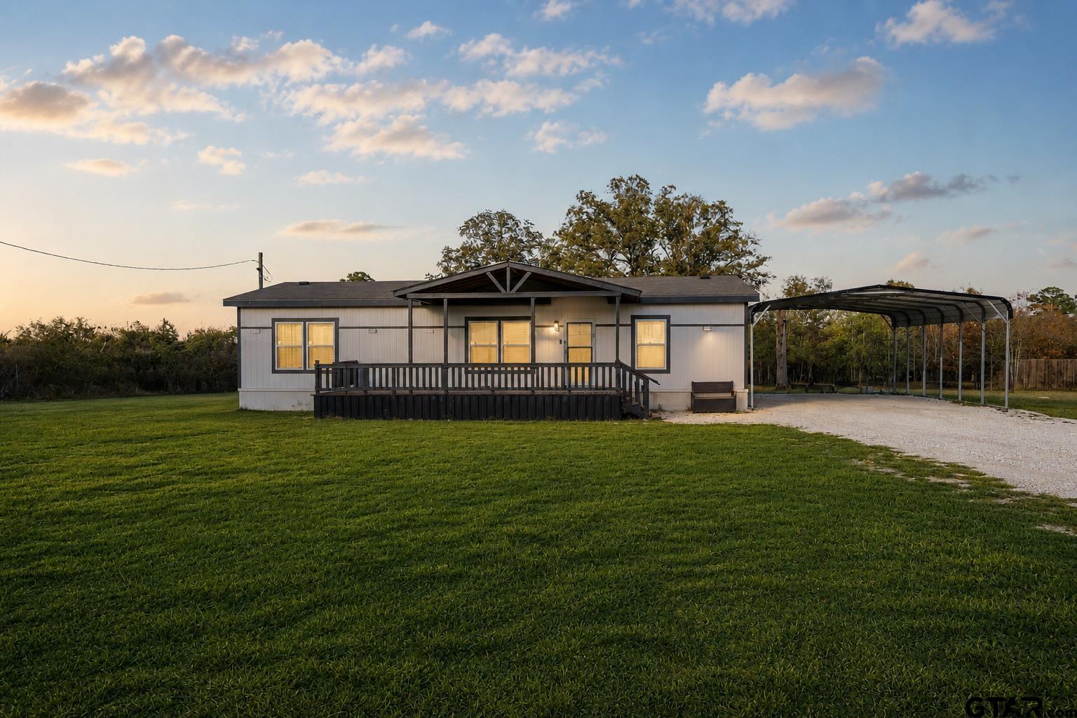 1255 Raintree Lakes Circle Big Sandy, TX 75755 - Photo 1 of 27 a front view of a house with a garden and deck
