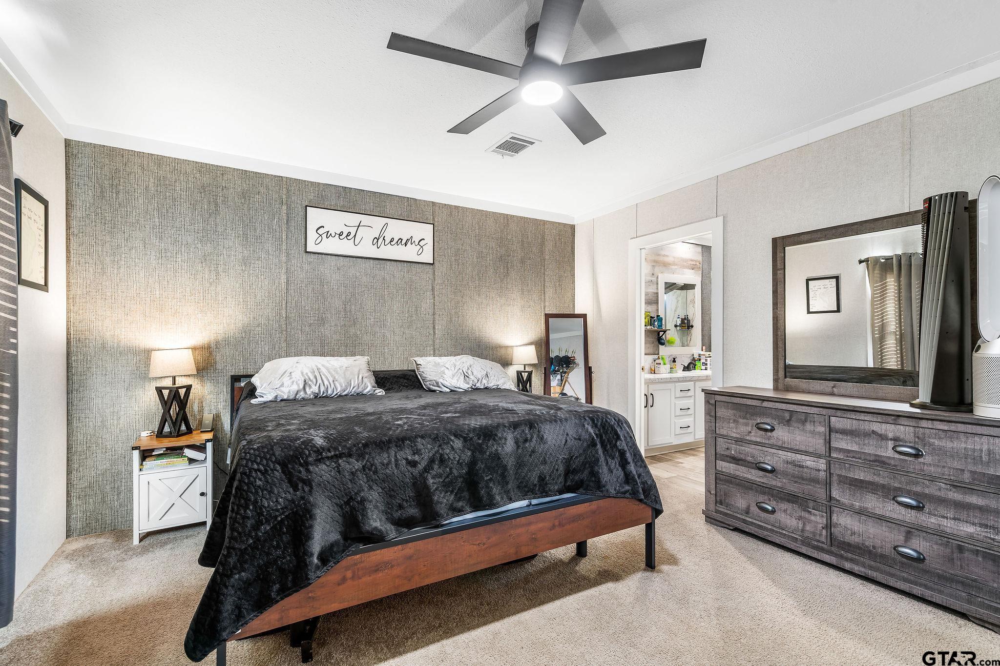 1255 Raintree Lakes Circle Big Sandy, TX 75755 - Photo 11 of 27 a bedroom with a bed and a mirror on the dresser