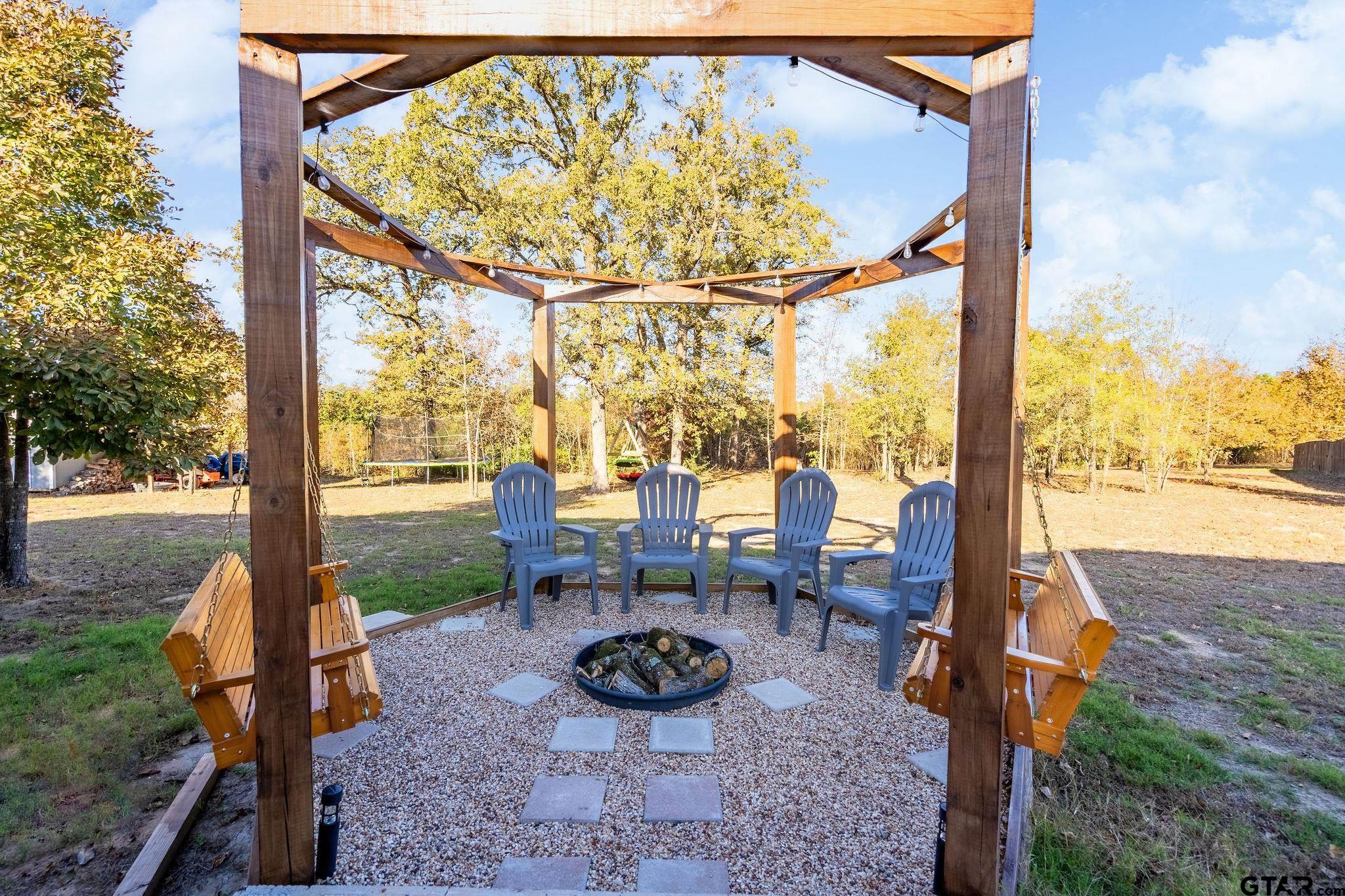 1255 Raintree Lakes Circle Big Sandy, TX 75755 - Photo 18 of 27 a view of a back yard with table and chairs
