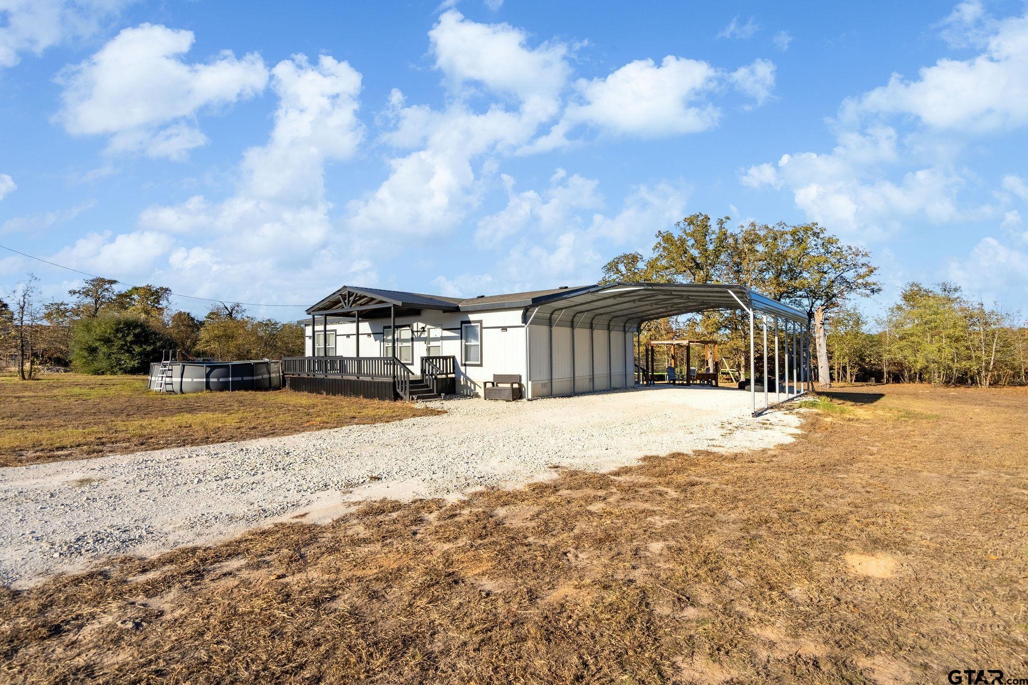 1255 Raintree Lakes Circle Big Sandy, TX 75755 - Photo 2 of 28 a yellow building with trees in front of it