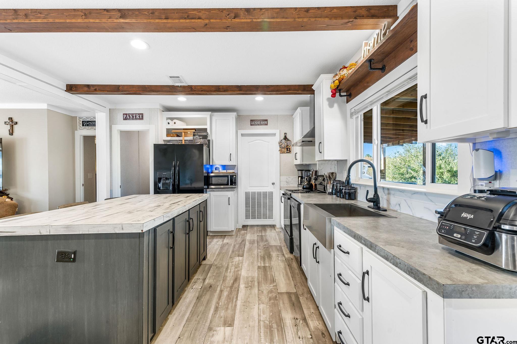 1255 Raintree Lakes Circle Big Sandy, TX 75755 - Photo 7 of 28 a large kitchen with granite countertop a sink counter space and stainless steel appliances