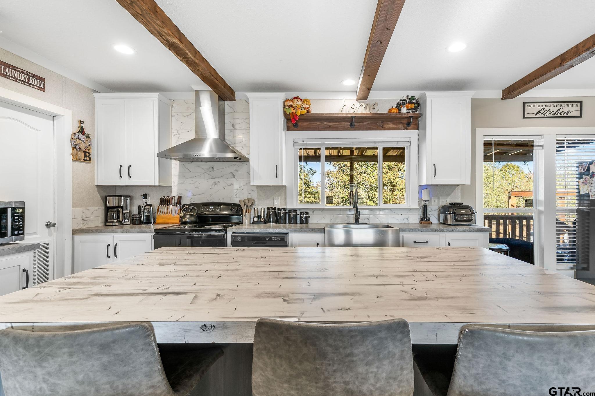 1255 Raintree Lakes Circle Big Sandy, TX 75755 - Photo 9 of 28 a large kitchen with stainless steel appliances kitchen island granite countertop a stove a sink dishwasher and white cabinets with wooden floor