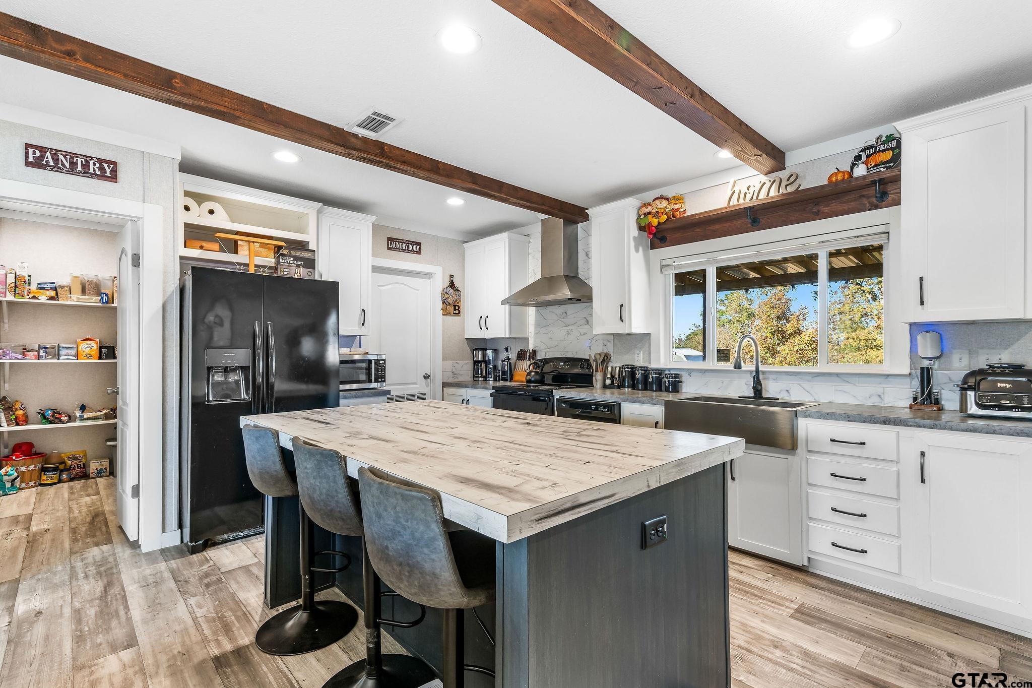 1255 Raintree Lakes Circle Big Sandy, TX 75755 - Photo 10 of 28 a kitchen with a stove a refrigerator and a wooden cabinets