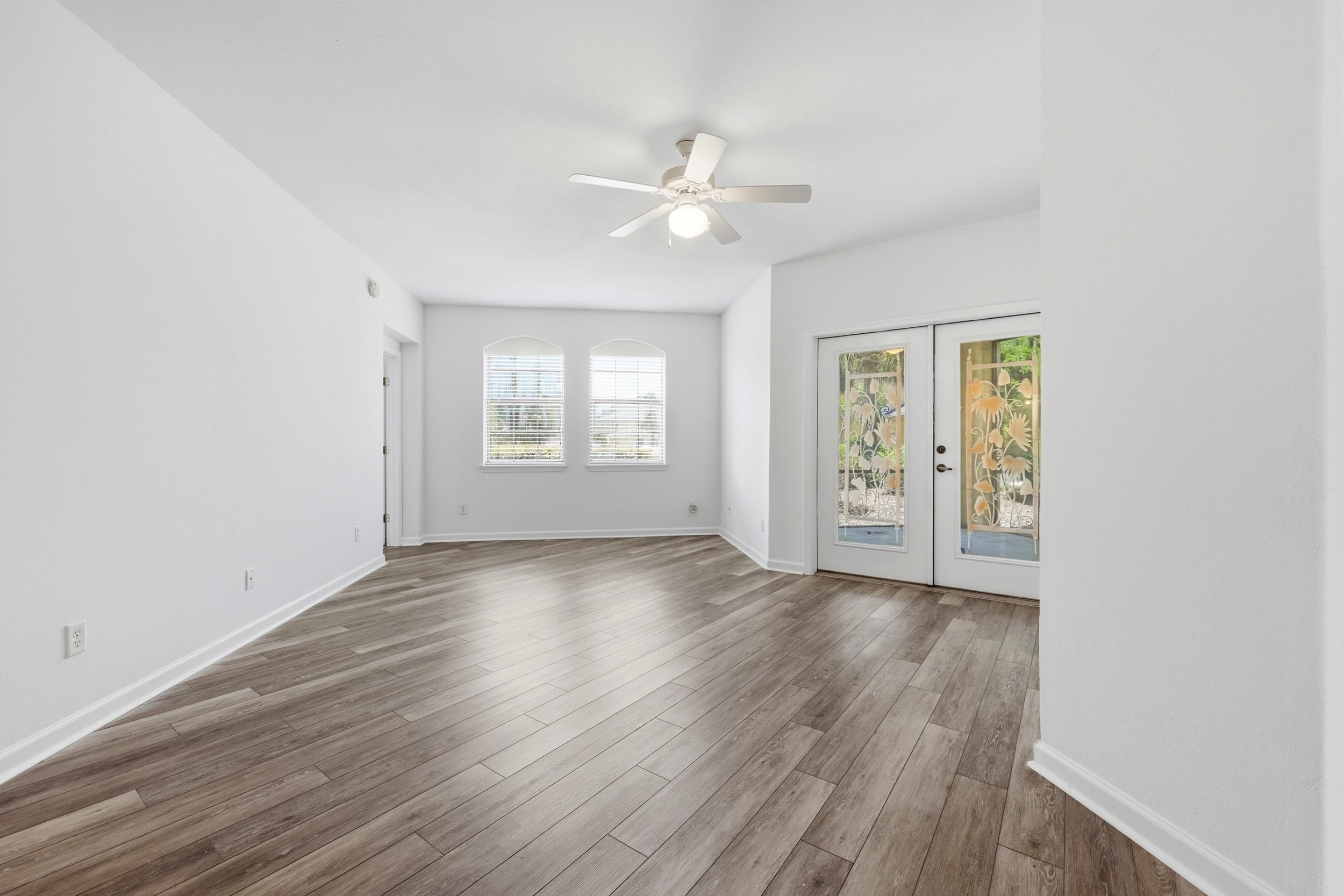 2500 Vista Cove Road St. Augustine, FL 32084 - Photo 18 of 53 an empty room with wooden floor ceiling fan and windows
