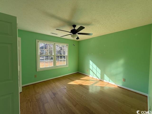 983 Nottingham Lakes Road Conway, SC 29526 - Photo 12 of 27 Empty room with wood finished floors, a textured ceiling, and a ceiling fan