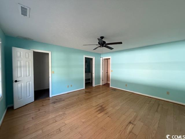 983 Nottingham Lakes Road Conway, SC 29526 - Photo 15 of 27 Unfurnished bedroom with a walk in closet, ceiling fan, wood-type flooring, and ensuite bath