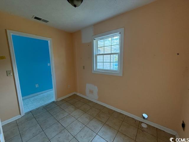 983 Nottingham Lakes Road Conway, SC 29526 - Photo 19 of 27 Empty room with a textured ceiling and light tile patterned flooring