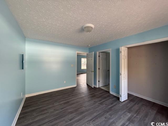 983 Nottingham Lakes Road Conway, SC 29526 - Photo 25 of 27 Unfurnished bedroom featuring a textured ceiling, a closet, and dark wood finished floors
