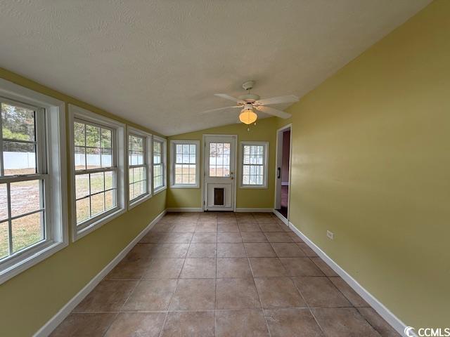 983 Nottingham Lakes Road Conway, SC 29526 - Photo 27 of 27 Unfurnished sunroom featuring tile patterned flooring, vaulted ceiling, and a textured ceiling