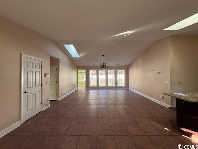 983 Nottingham Lakes Road Conway, SC 29526 - Photo 3 of 27 Unfurnished living room featuring a skylight, vaulted ceiling, and dark tile patterned flooring