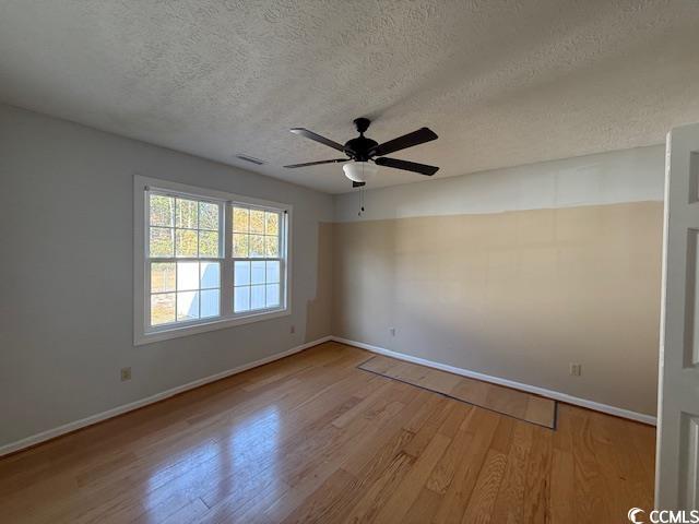 983 Nottingham Lakes Road Conway, SC 29526 - Photo 10 of 27 Empty room with light wood finished floors, a ceiling fan, and a textured ceiling