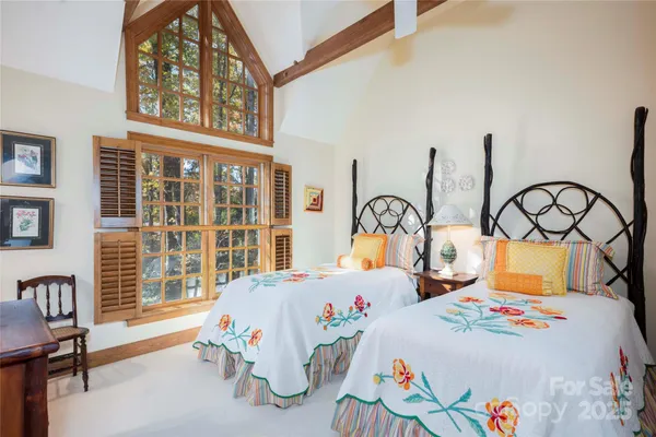 a bedroom with two beds and a large window
