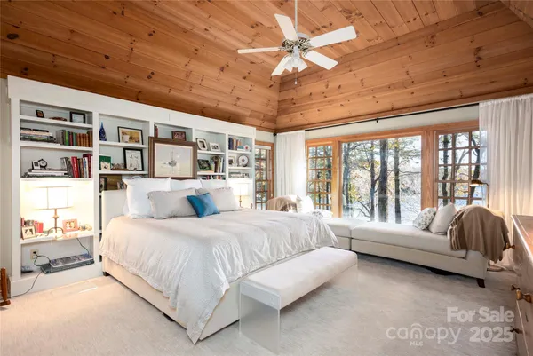 a spacious bedroom with a bed couch and a large window