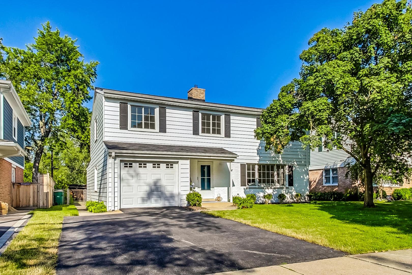 a front view of a house with a yard and trees
