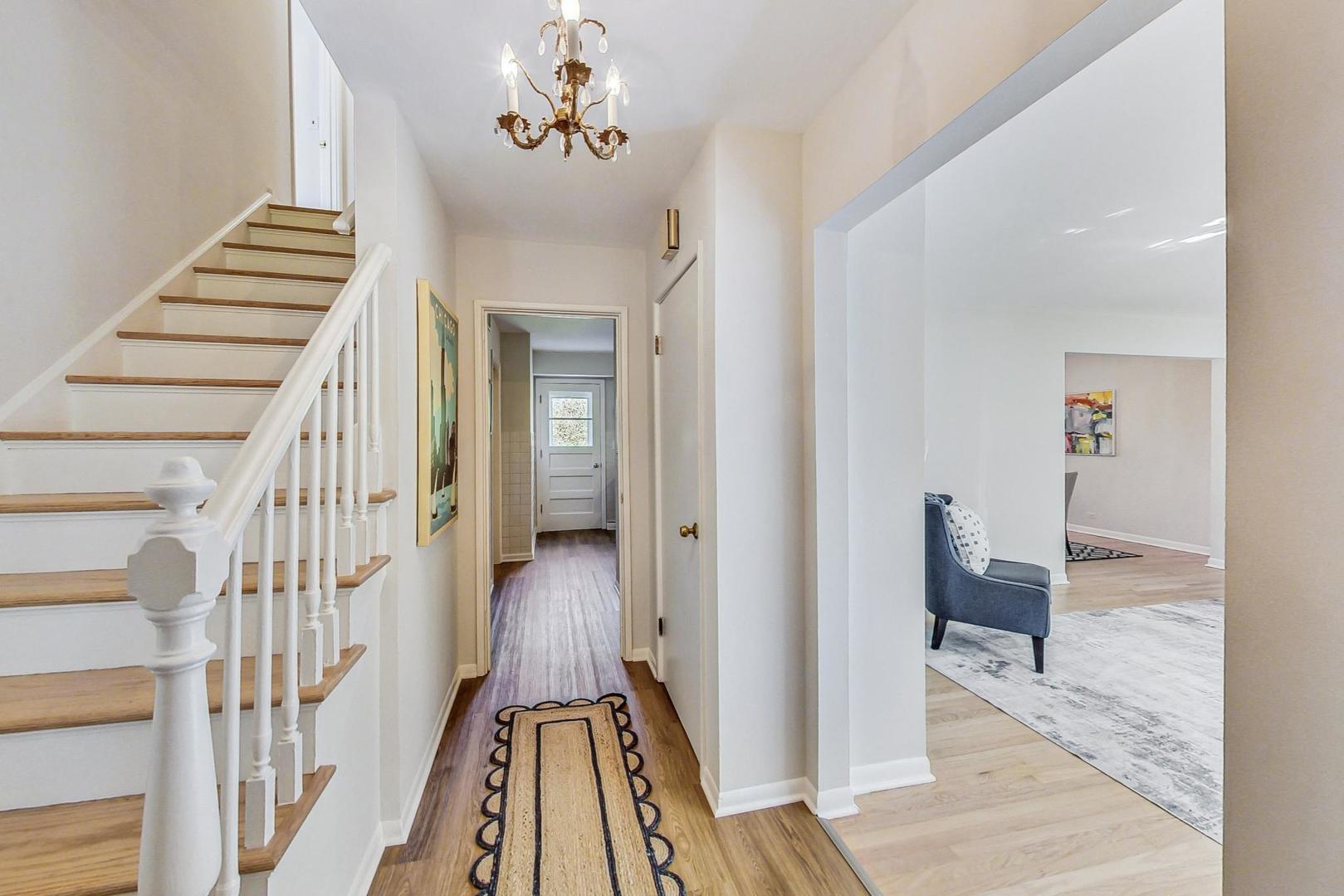 157 Riverside Drive Northfield, IL 60093 - Photo 4 of 21 a view of a hallway with wooden floor and stairs