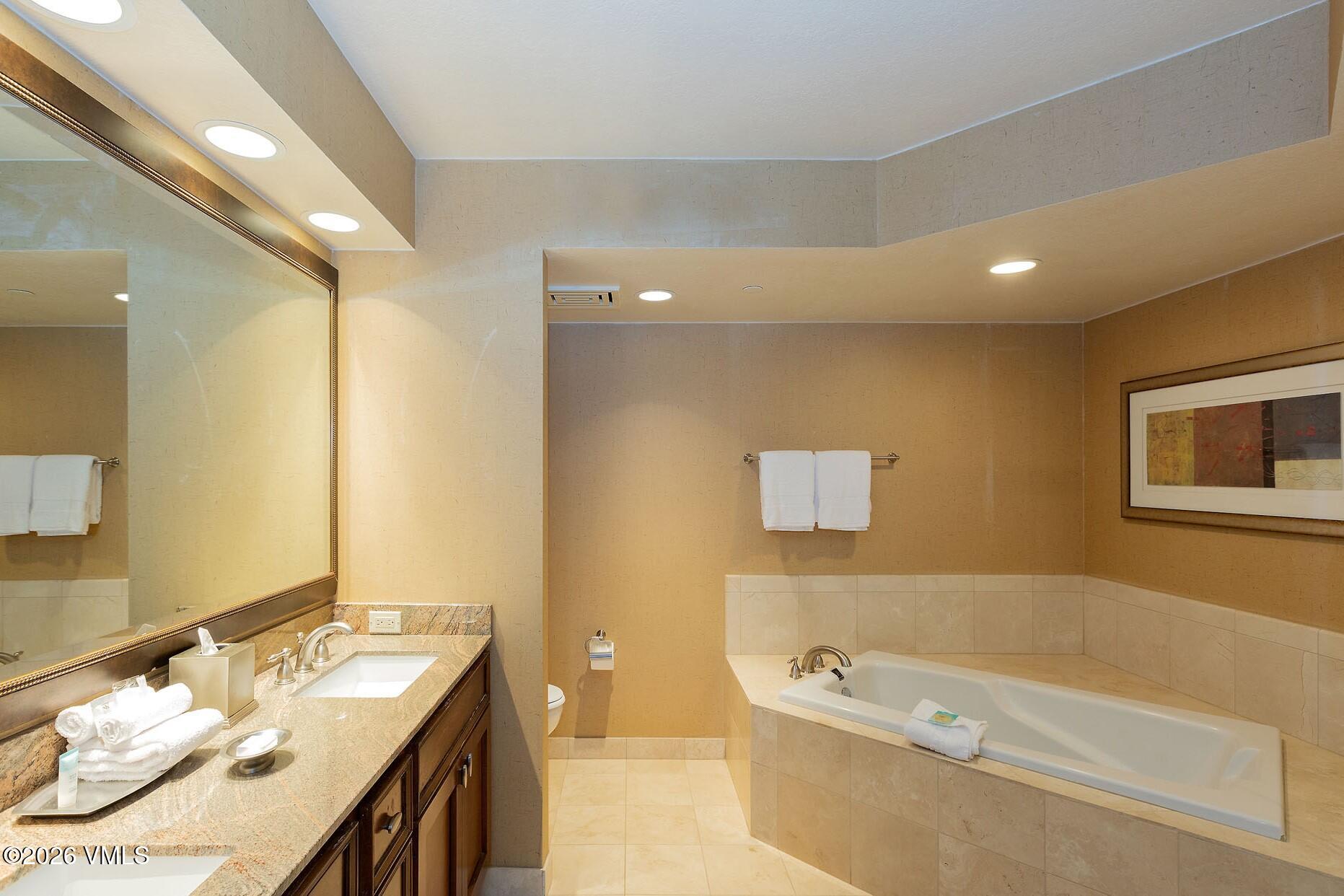 210 Offerson Road, Unit R305 WEEK 14 Beaver Creek, CO 81620 - Photo 15 of 24 a bathroom with a tub a sink and a mirror