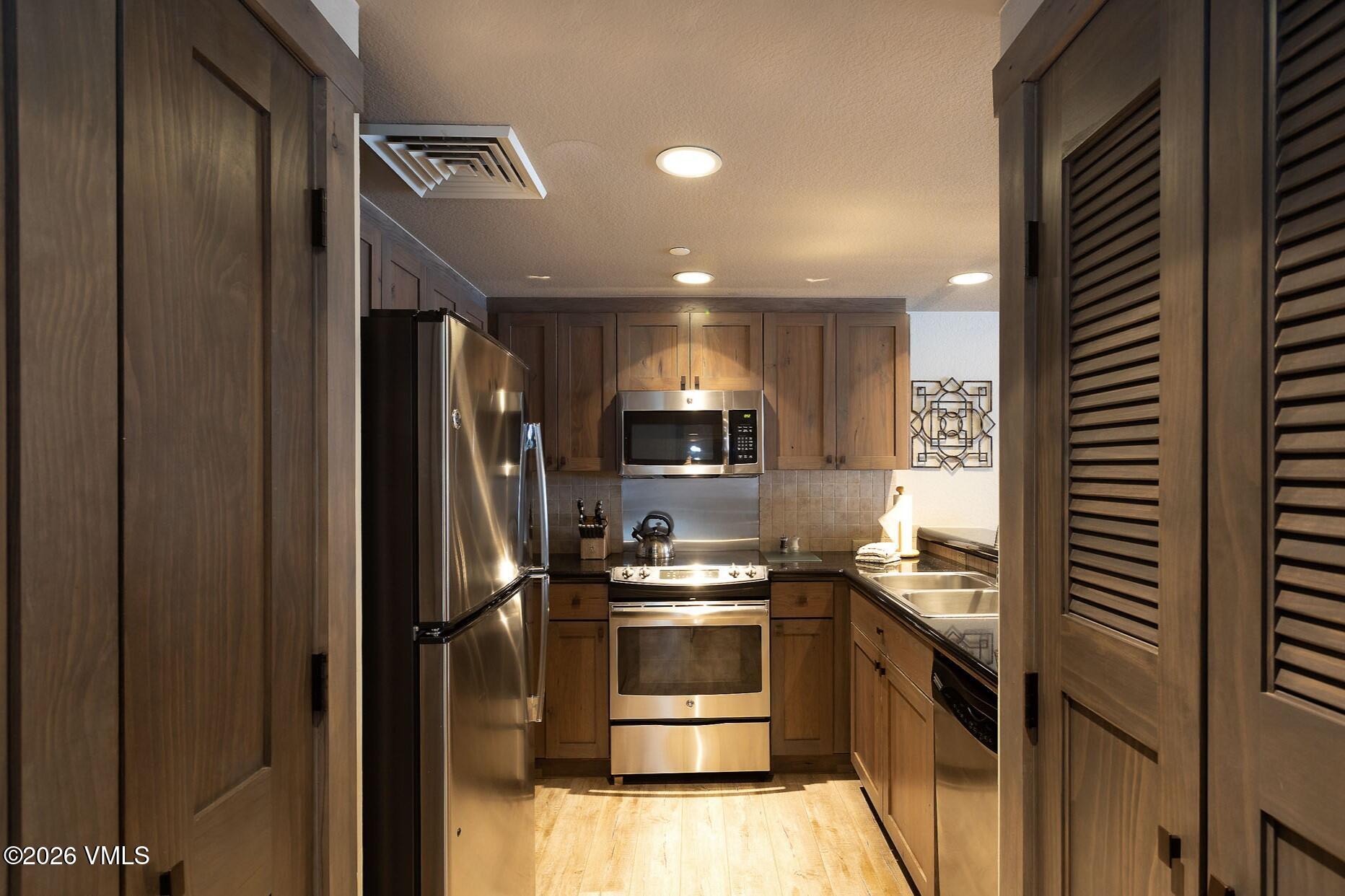 210 Offerson Road, Unit R305 WEEK 14 Beaver Creek, CO 81620 - Photo 8 of 24 a kitchen with a sink and stainless steel appliances