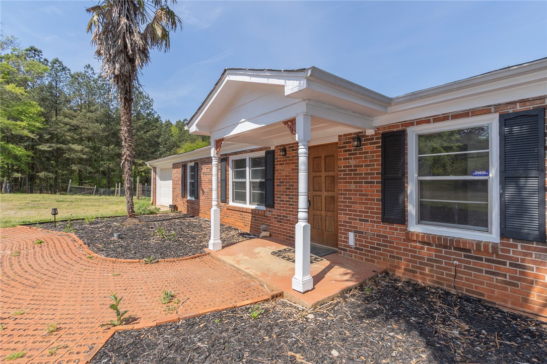 820 Travis Road Anderson, SC 29626 - Photo 10 of 46 This classic brick residence features an inviting front porch and a paved walkway leading to the entrance.