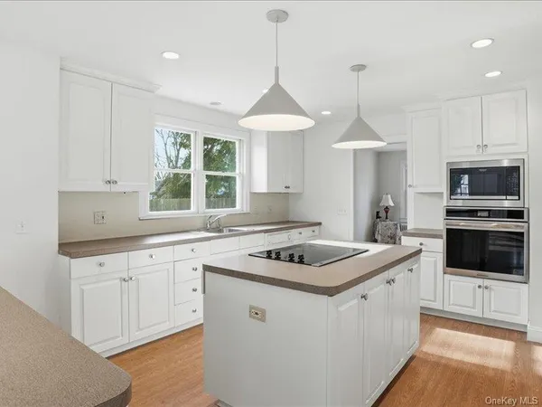 a kitchen that has a sink a window and stainless steel appliances