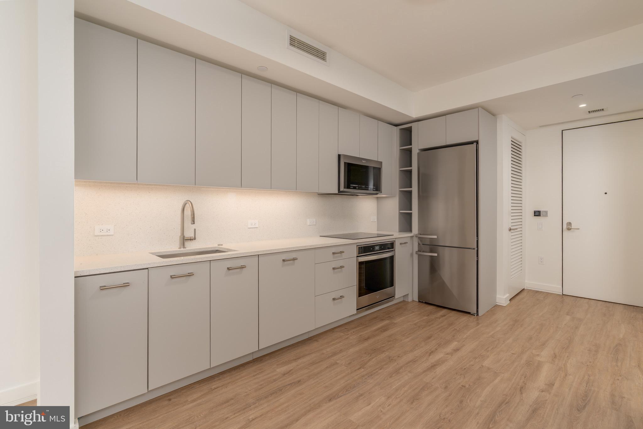 1630 Columbia Road Northwest, Unit 904 Washington, DC 20009 - Photo 4 of 20 a kitchen with a sink cabinets and stainless steel appliances
