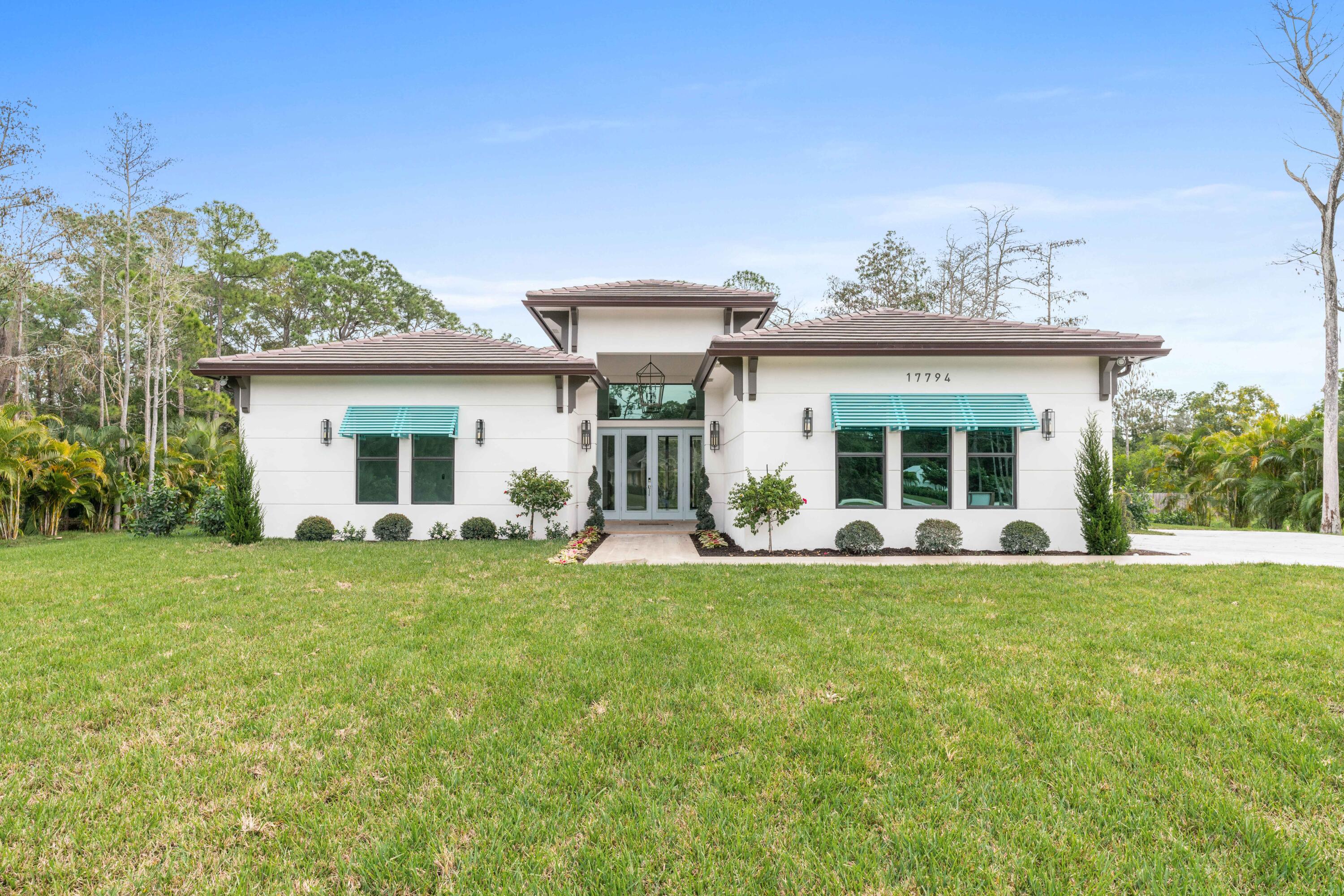 a view of a house with a patio and a yard