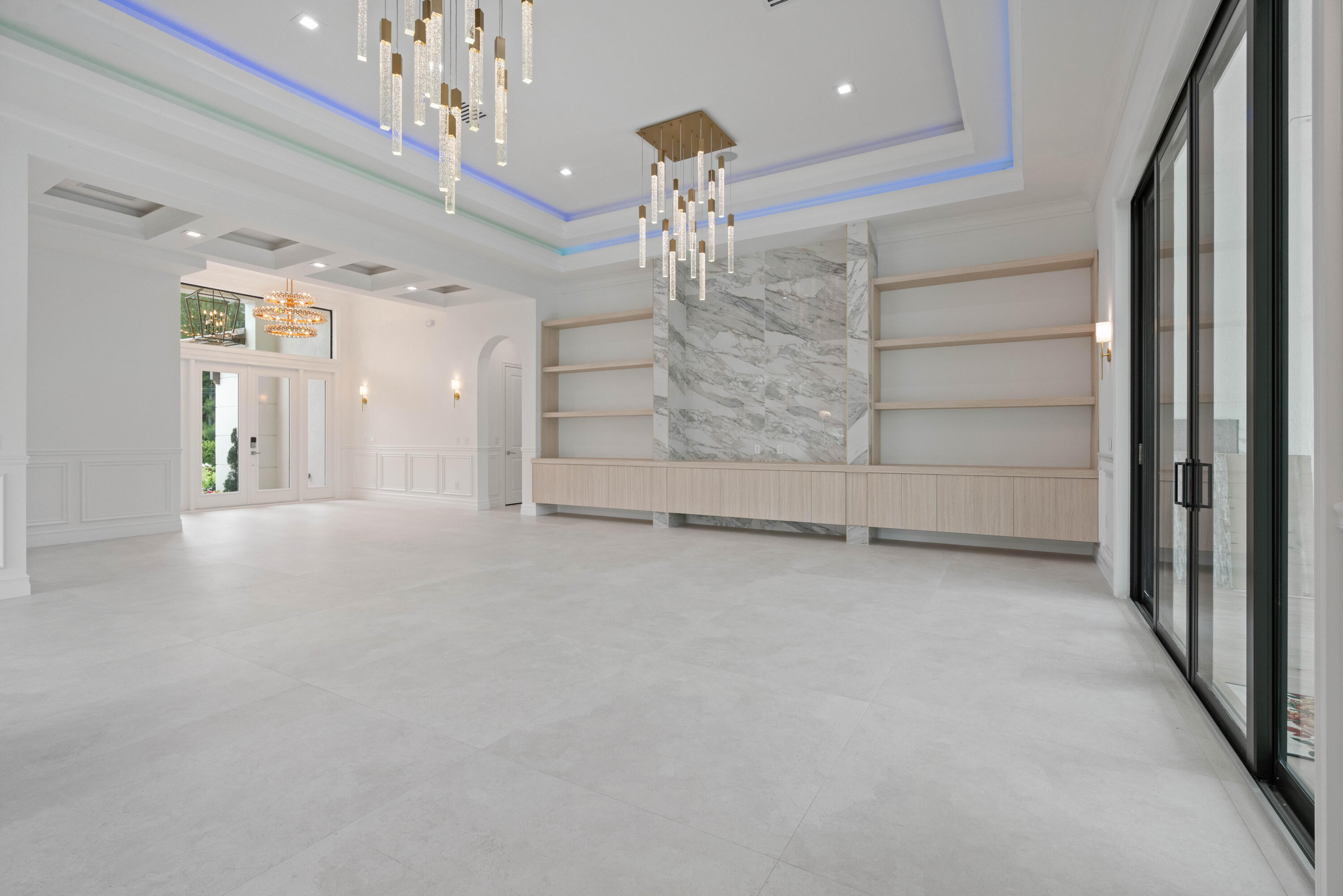 17794 Mellen Lane Jupiter, FL 33478 - Photo 14 of 45 en empty room with fireplace and chandelier