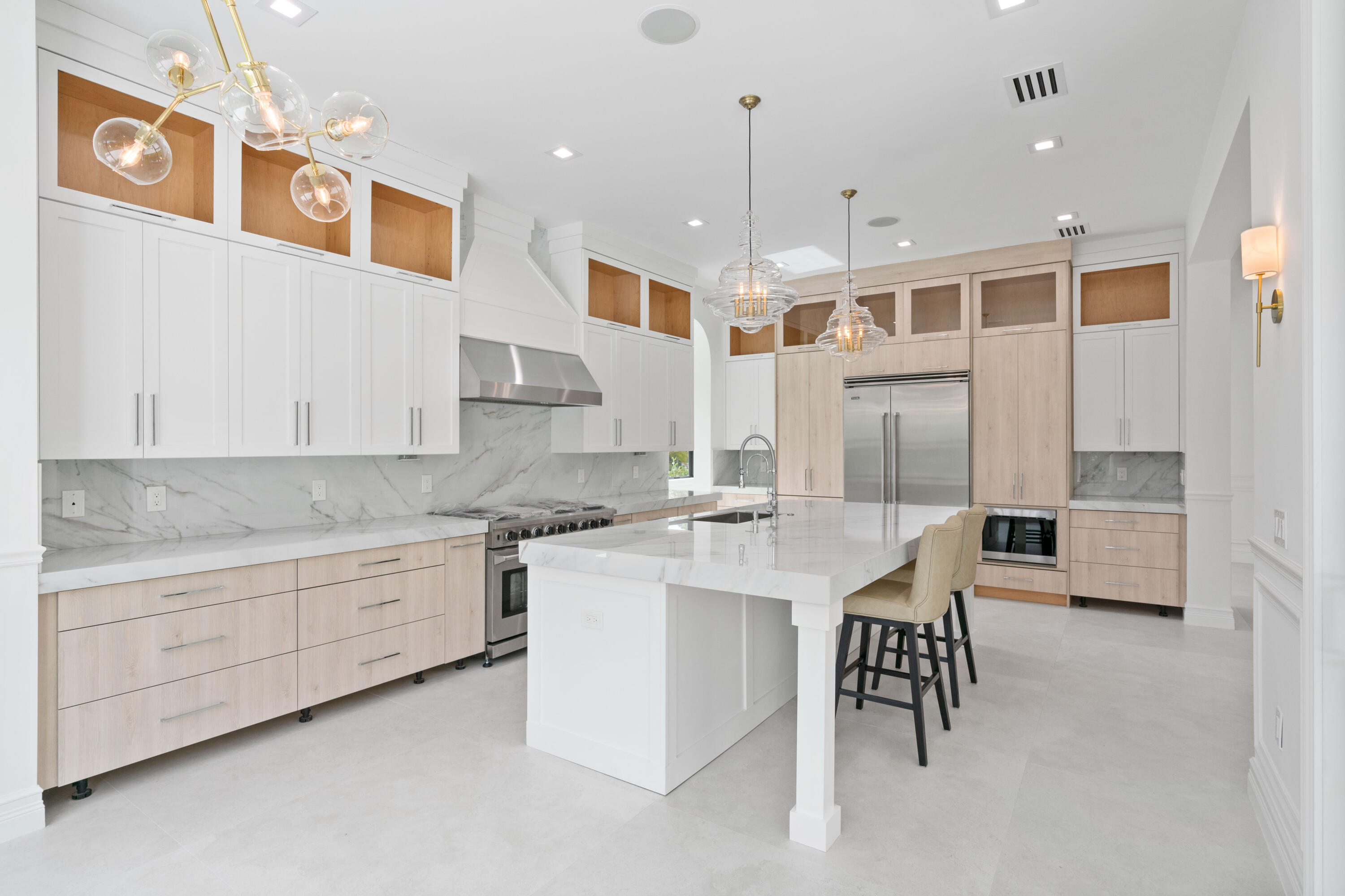 17794 Mellen Lane Jupiter, FL 33478 - Photo 17 of 45 a kitchen with stainless steel appliances kitchen island granite countertop a table chairs sink and cabinets