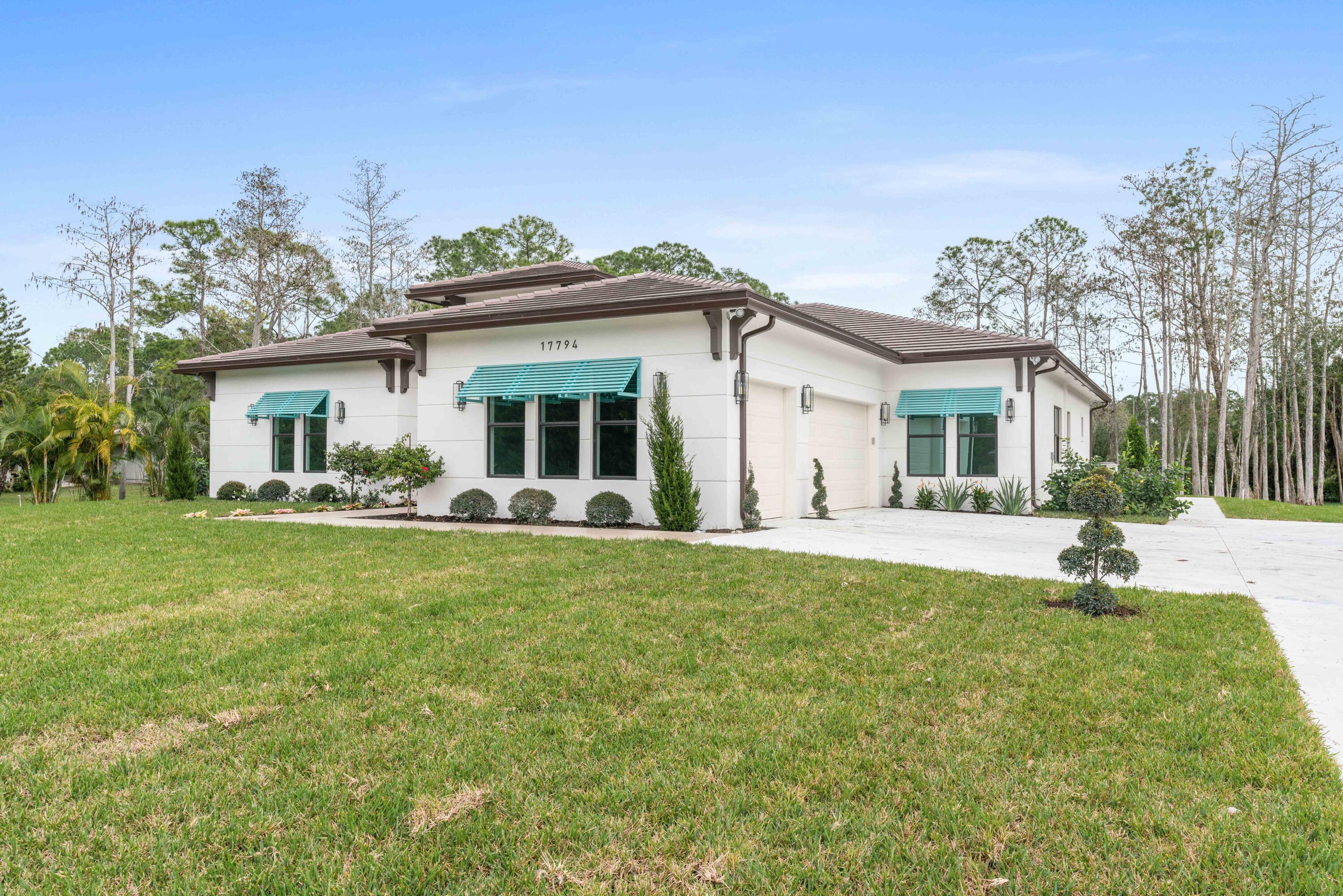 17794 Mellen Lane Jupiter, FL 33478 - Photo 8 of 45 a front view of a house with a garden