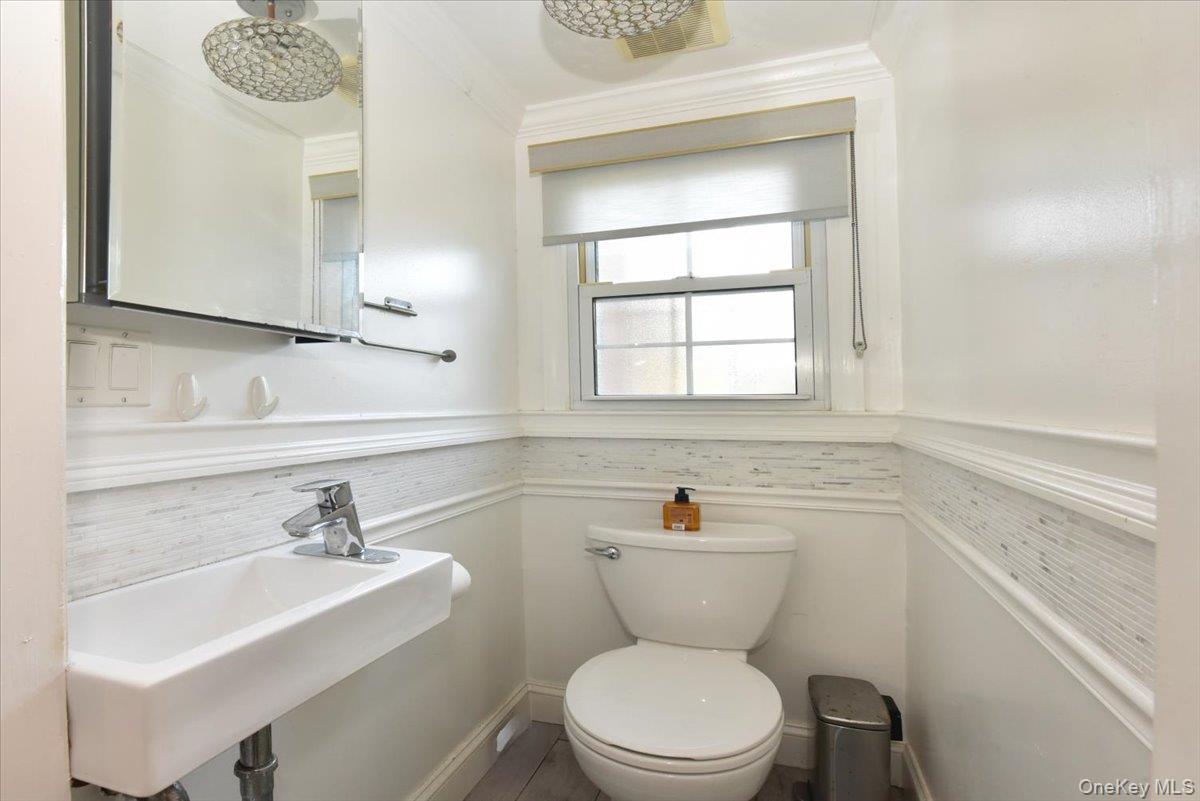 193-46 McLaughlin Avenue Queens, NY 11423 - Photo 19 of 34 a bathroom with a sink a toilet and a mirror