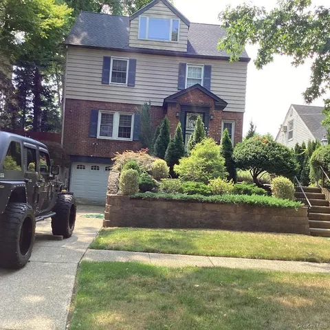 a front view of a house with a yard and potted plants