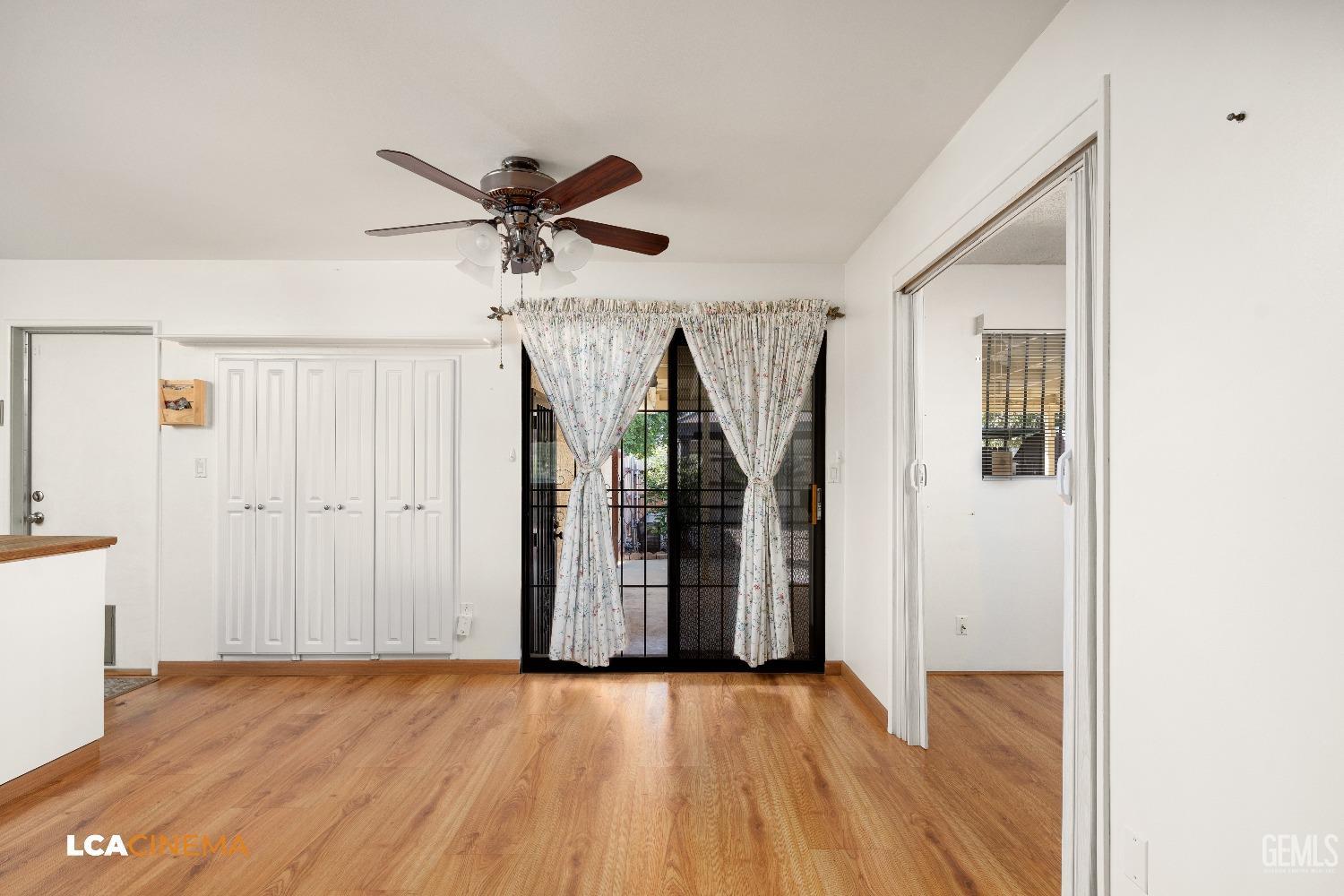 Undisclosed Address Bakersfield, CA 93306 - Photo 7 of 20 a view of an empty room with wooden floor and a ceiling fan