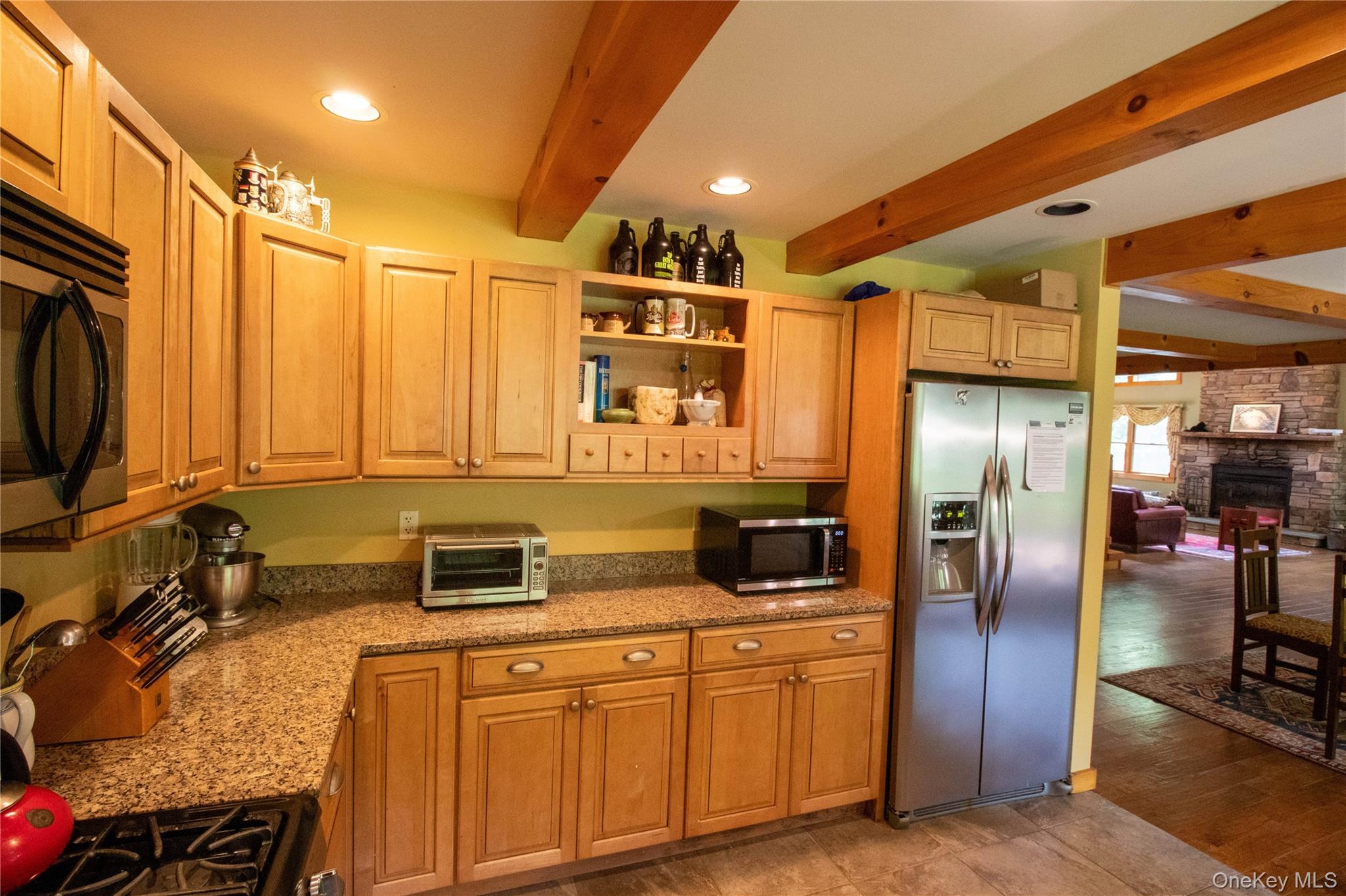 384 Morton Hill Road Roscoe, NY 12776 - Photo 12 of 27 Kitchen with beam ceiling, open shelves, appliances with stainless steel finishes, light stone counters, and a fireplace