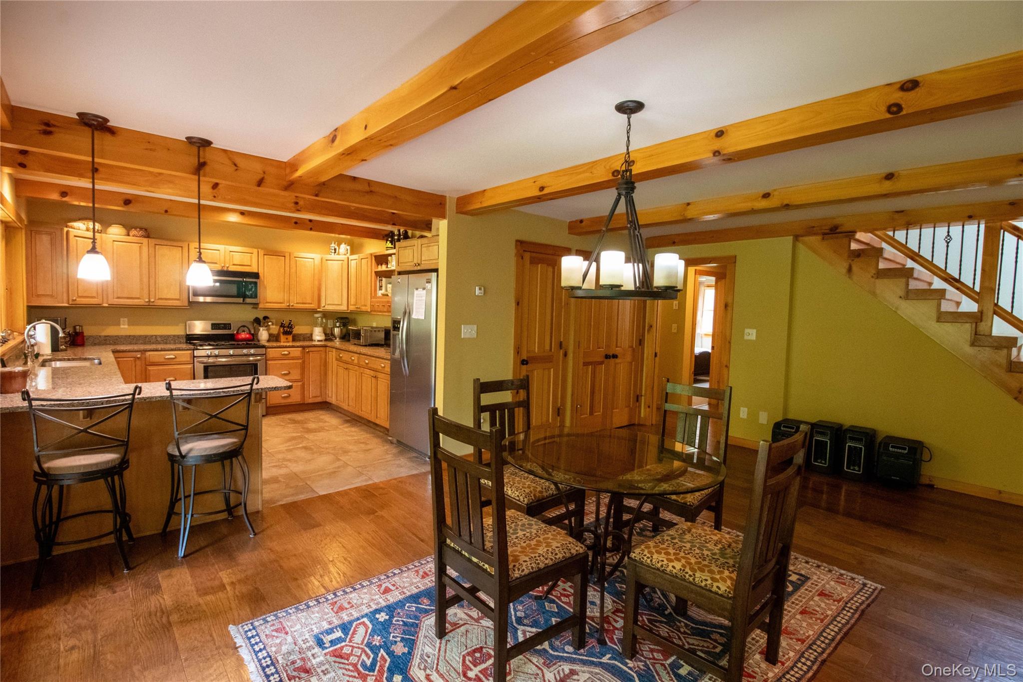 384 Morton Hill Road Roscoe, NY 12776 - Photo 14 of 27 Dining area with stairs, light wood finished floors, beamed ceiling, and a chandelier