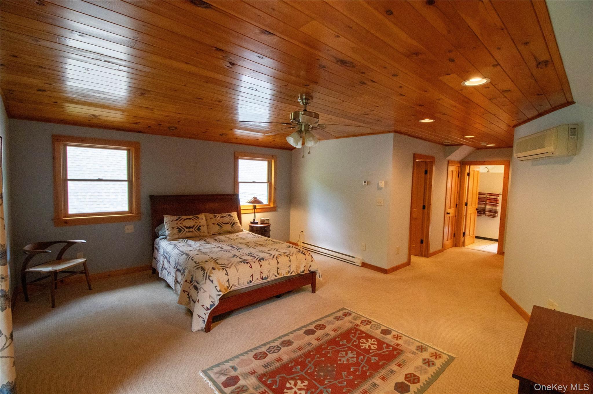 384 Morton Hill Road Roscoe, NY 12776 - Photo 17 of 27 Bedroom with light colored carpet, a baseboard radiator, wooden ceiling, recessed lighting, and a wall mounted AC