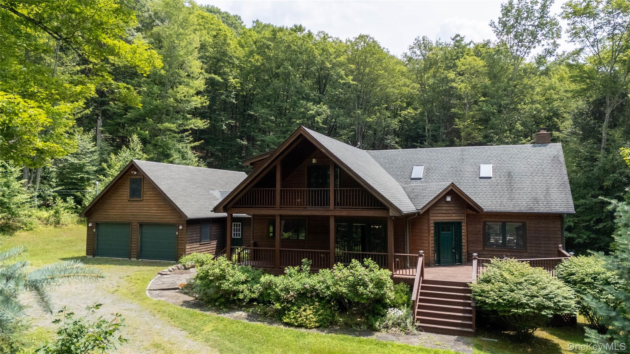 384 Morton Hill Road Roscoe, NY 12776 - Photo 25 of 27 View of front facade featuring a garage, a porch, a wooded view, and a shingled roof