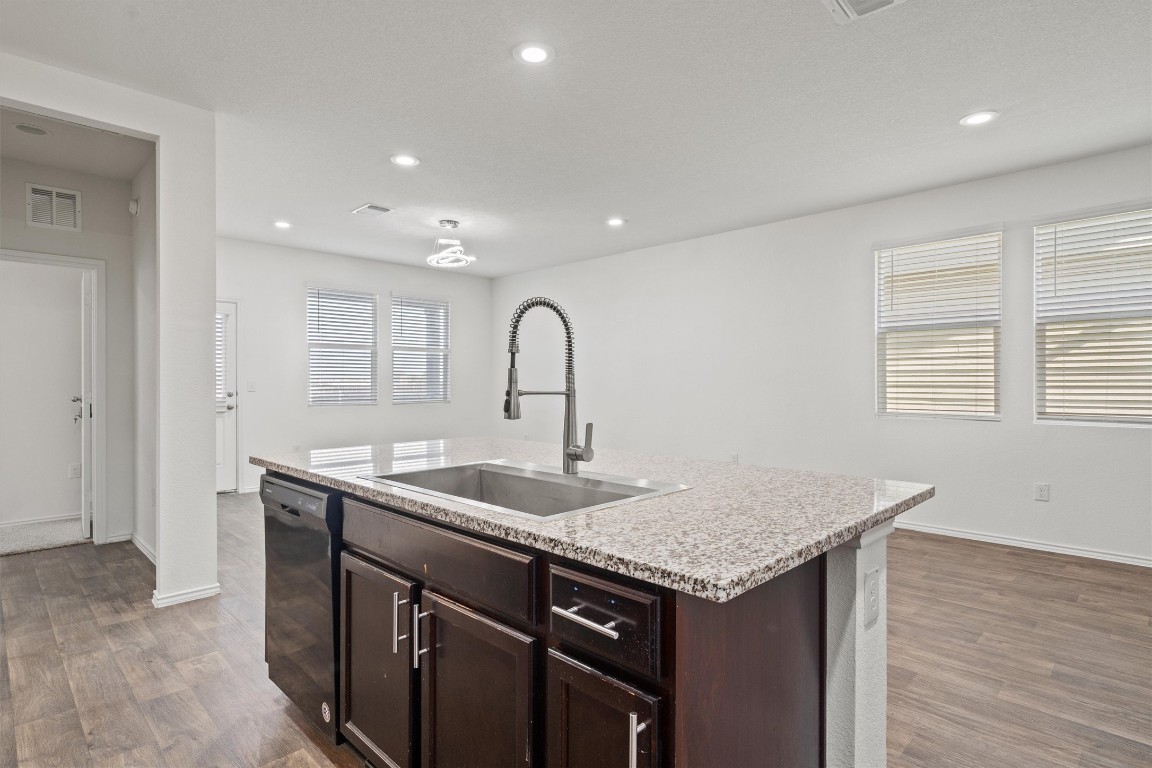 11908 Pyrite Road Manor, TX 78653 - Photo 11 of 35 a kitchen with a granite countertop sink and natural light