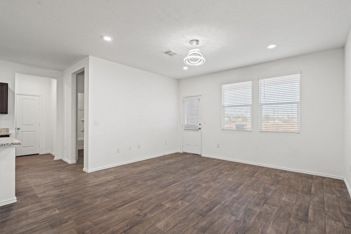 11908 Pyrite Road Manor, TX 78653 - Photo 7 of 35 an empty room with wooden floor and windows