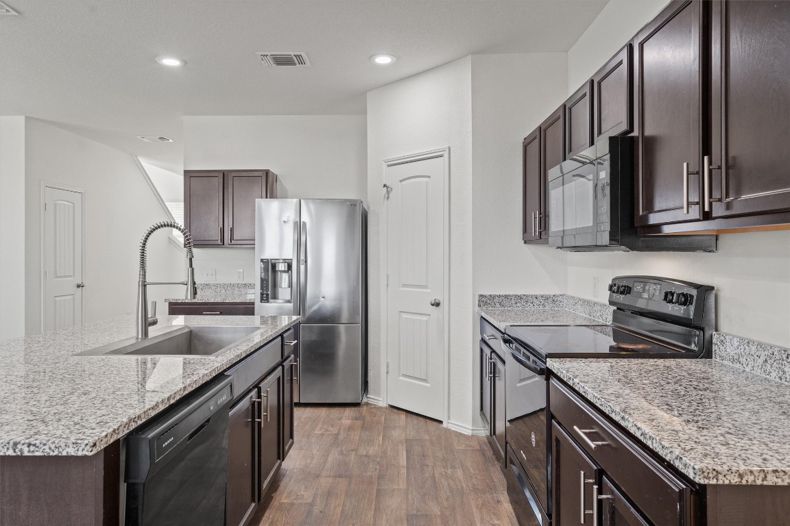 11908 Pyrite Road Manor, TX 78653 - Photo 9 of 35 a kitchen with stainless steel appliances granite countertop a sink stove and refrigerator