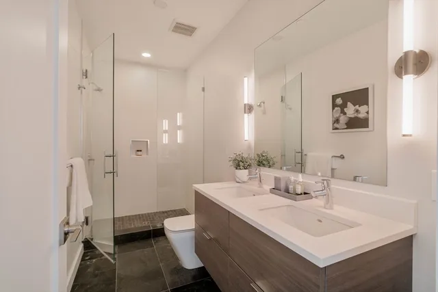 a bathroom with a sink mirror and toilet