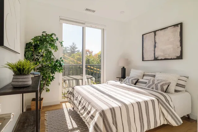 a bedroom with a large bed and a potted plant