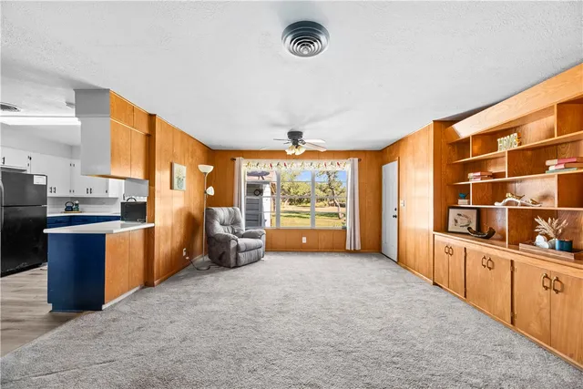 a large living room with stainless steel appliances kitchen island granite countertop a refrigerator stove and sink