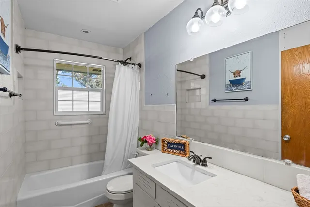 a bathroom with a sink vanity mirror and a toilet