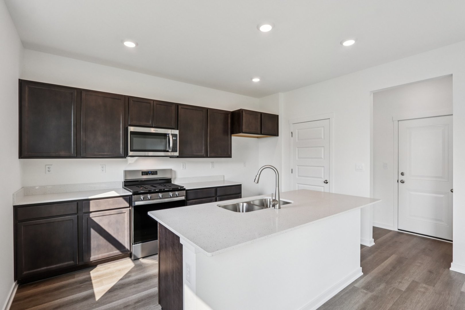 1552 Aspen Lane Pingree Grove, IL 60140 - Photo 12 of 73 a kitchen with stainless steel appliances a sink a stove a microwave and cabinets