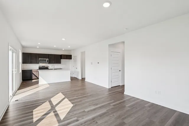 a kitchen with stainless steel appliances a sink a stove a microwave a refrigerator a counter top space and cabinets