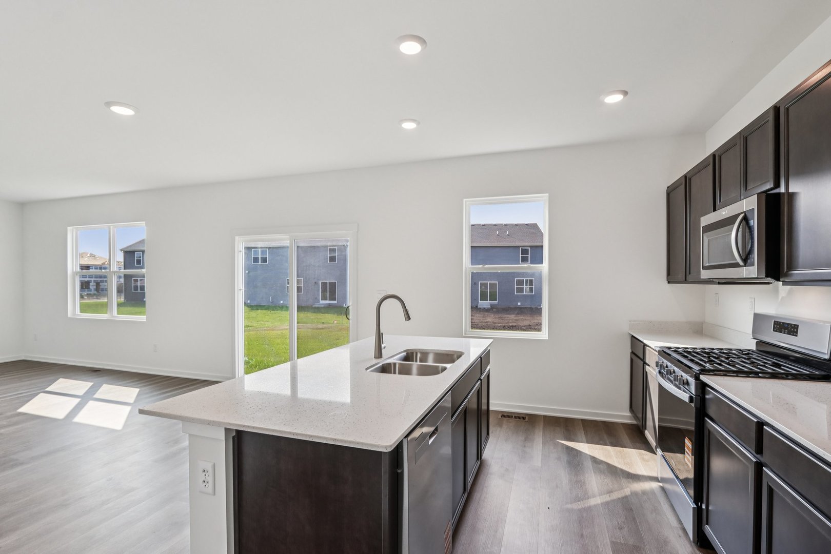 1552 Aspen Lane Pingree Grove, IL 60140 - Photo 8 of 73 a kitchen with stainless steel appliances a sink a stove cabinets and wooden floor