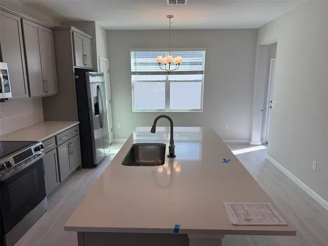 a kitchen with sink a refrigerator and a stove