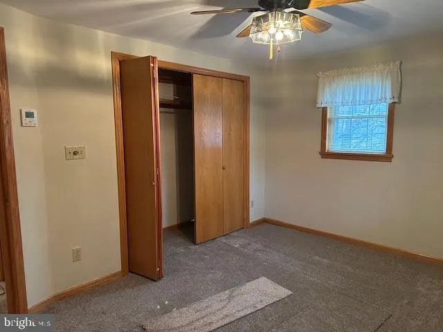 an empty room with chandelier fan