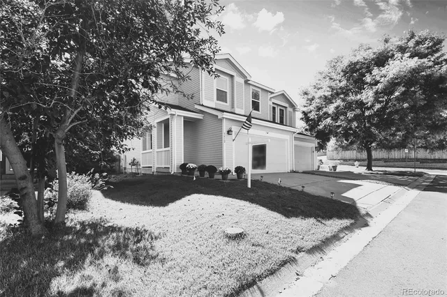 a front view of a house with a yard covered in snow