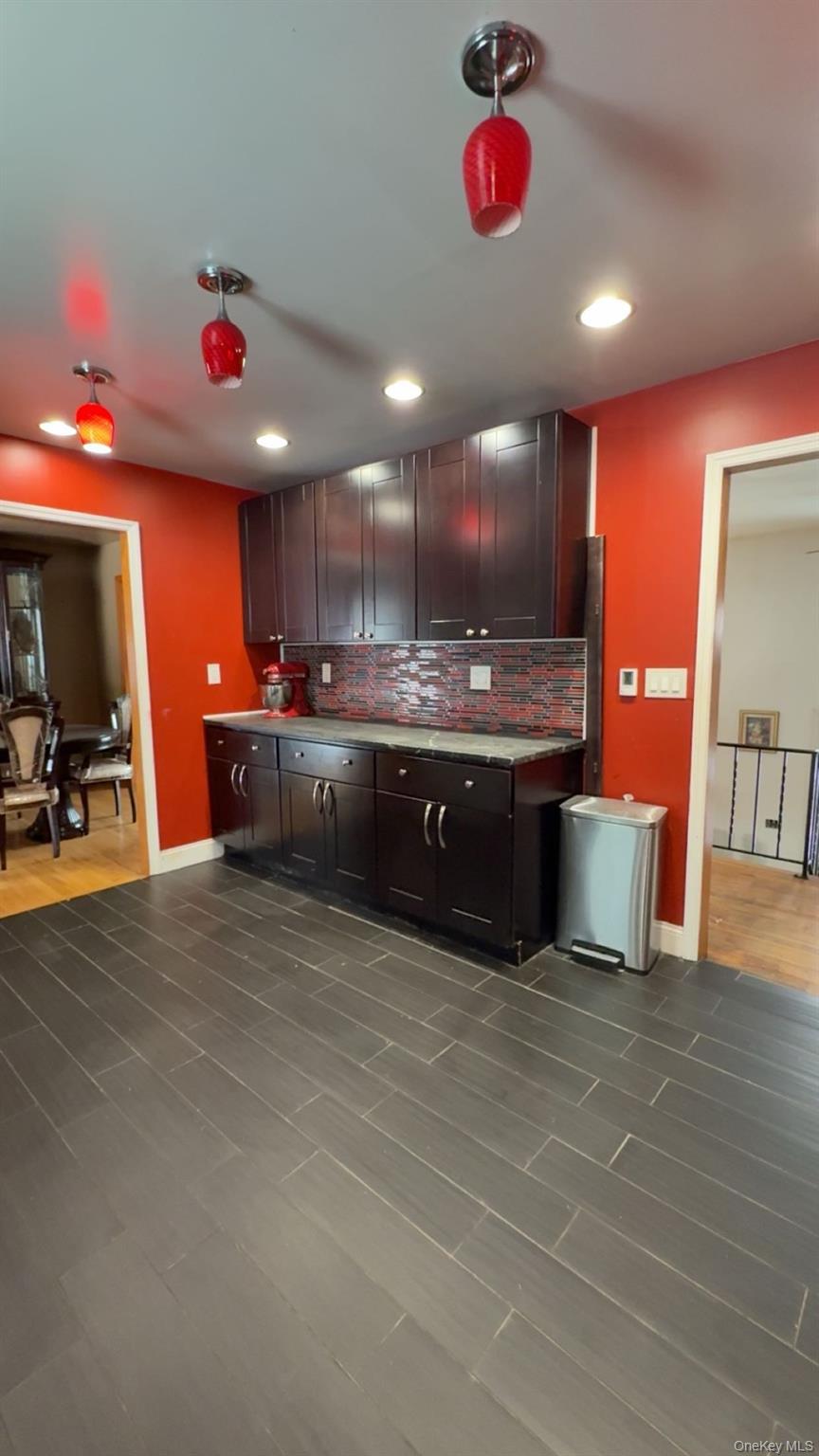 93 Old Mill Road Wallkill, NY 12589 - Photo 16 of 39 Kitchen with decorative backsplash, light countertops, dark brown cabinetry, and dark wood finished floors