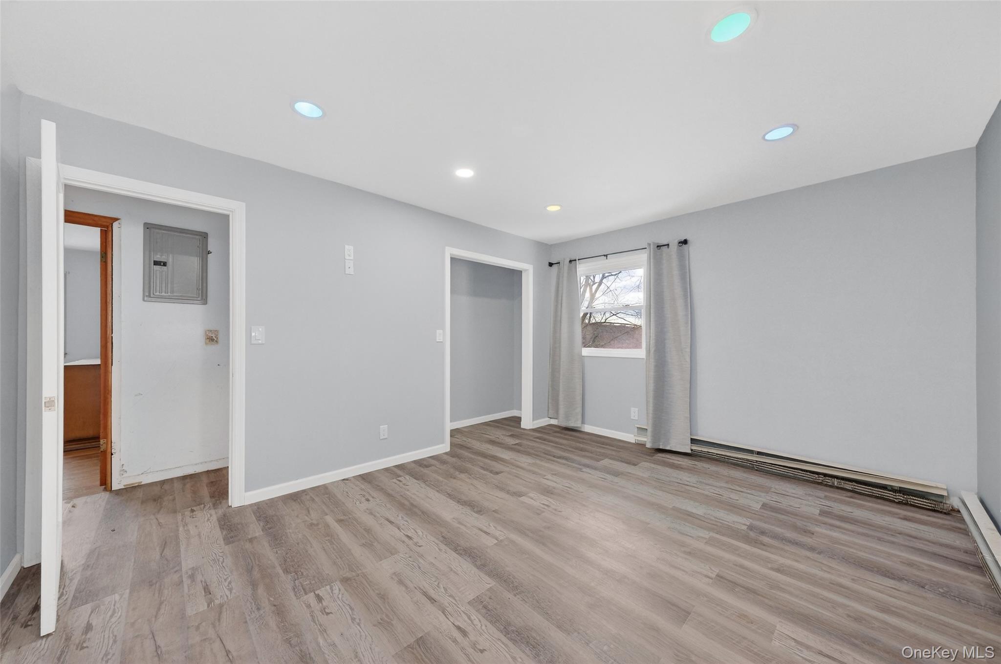 93 Old Mill Road Wallkill, NY 12589 - Photo 17 of 39 Unfurnished bedroom featuring light wood-style floors, electric panel, a baseboard radiator, recessed lighting, and baseboard heating